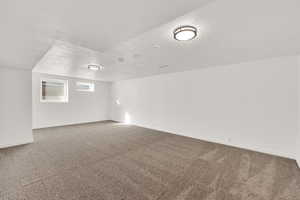 Empty room with carpet flooring and a textured ceiling