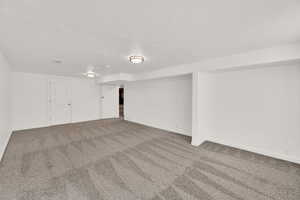 Carpeted spare room featuring a textured ceiling