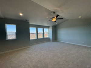 Spare room with ceiling fan, light colored carpet, and a textured ceiling