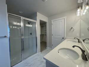 Bathroom with vanity, a textured ceiling, and walk in shower