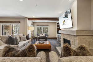 Living room with plenty of natural light, dark hardwood / wood-style floors, and a fireplace