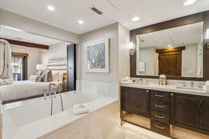 Bathroom with vanity, tiled bath, and tile patterned floors