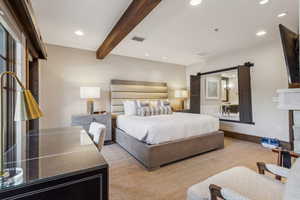 Carpeted bedroom with beamed ceiling and a barn door