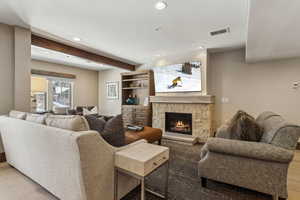 Living room with hardwood / wood-style flooring, a fireplace, and beam ceiling