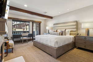 Bedroom featuring light carpet and beam ceiling