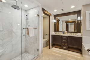 Bathroom with vanity, toilet, and an enclosed shower