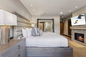 Bedroom featuring a barn door and a stone fireplace