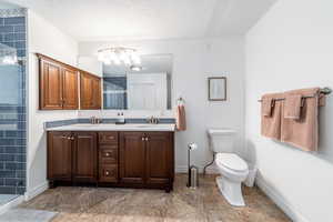 Bathroom with vanity, toilet, a textured ceiling, and walk in shower