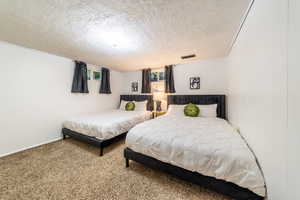 Bedroom with carpet and a textured ceiling