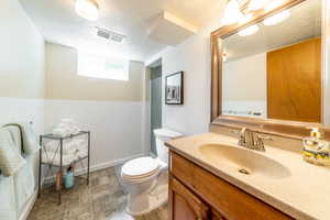 Bathroom featuring vanity, toilet, and a textured ceiling