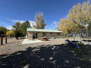 Rear view of property featuring a trampoline, a patio area, and a playground