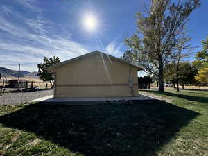 View of side of home featuring a playground, a mountain view, and a lawn