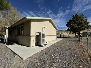 View of side of property featuring a mountain view, a patio, and central air condition unit