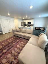 Living room featuring dark wood-type flooring and a textured ceiling