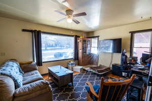 Living room with hardwood / wood-style floors and ceiling fan