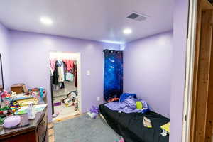 Bedroom featuring a walk in closet and a closet