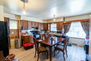 Dining room with sink and light wood-type flooring