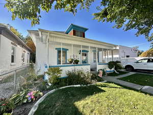 View of front of property with covered porch and a front yard