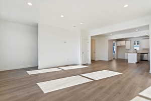 Unfurnished living room with sink and light wood-type flooring