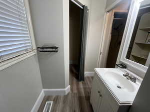 Bathroom with wood-type flooring, vanity, and a shower