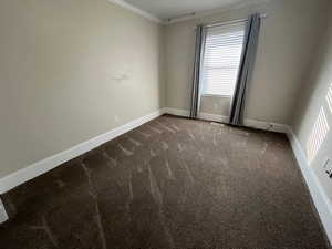 Carpeted spare room with crown molding