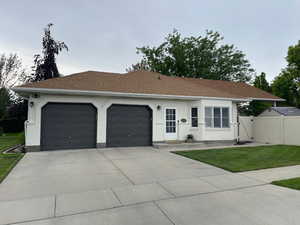 Ranch-style house with a garage and a front yard