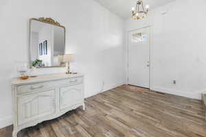 Foyer entrance featuring an inviting chandelier and light hardwood / wood-style flooring