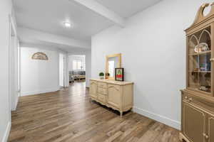 Hall with hardwood / wood-style floors and beamed ceiling