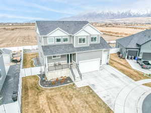 View of front of property featuring a porch, a mountain view, and a garage