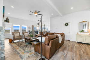 Living room featuring beamed ceiling, ceiling fan, and light hardwood / wood-style floors