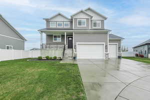 Craftsman house featuring board and batten siding, covered porch, driveway, a garage, and stone siding