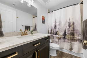 Bathroom featuring hardwood / wood-style flooring, vanity, and toilet