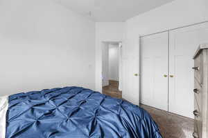 Carpeted bedroom with a closet