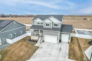 View of front of house with a porch, a garage, and a front yard