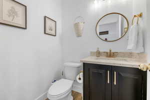 Bathroom with vanity, toilet, and hardwood / wood-style floors