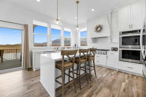 Kitchen featuring white cabinetry, stainless steel appliances, a mountain view, and a kitchen island