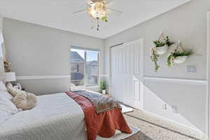 Bedroom with ceiling fan, a closet, and carpet