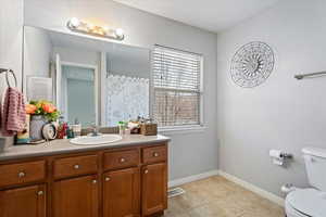 Bathroom featuring vanity, tile patterned floors, and toilet