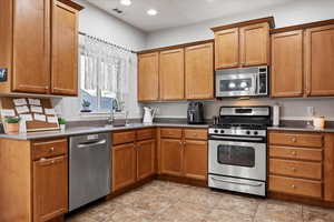 Kitchen with appliances with stainless steel finishes, sink, and light tile patterned floors