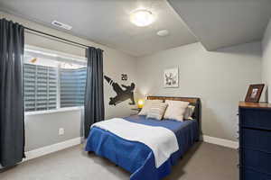 Carpeted bedroom with a textured ceiling