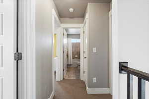 Hall featuring carpet and a textured ceiling