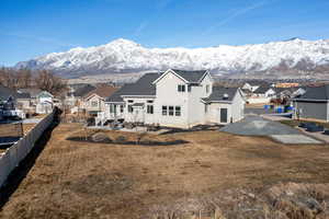 Back of property with a mountain view and a lawn