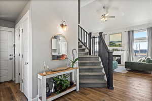 Staircase with wood-type flooring and ceiling fan