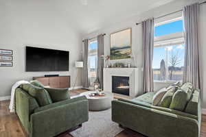 Living room with hardwood / wood-style flooring and vaulted ceiling