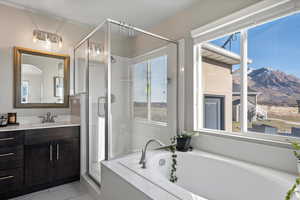 Bathroom with independent shower and bath, vanity, and a mountain view