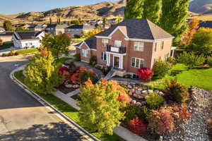 View of front of home with brick siding, a mountain view, a residential view, and a front lawn