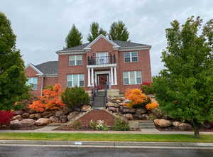 View of front of home with a balcony and fall colors