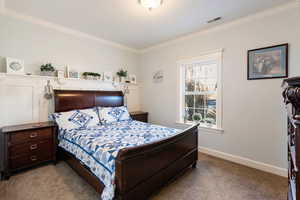 Carpeted bedroom featuring ornamental molding