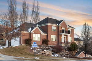 View of front of home with a garage and a balcony