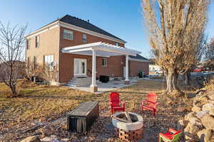 Back of property featuring a pergola, a patio area, and an outdoor fire pit